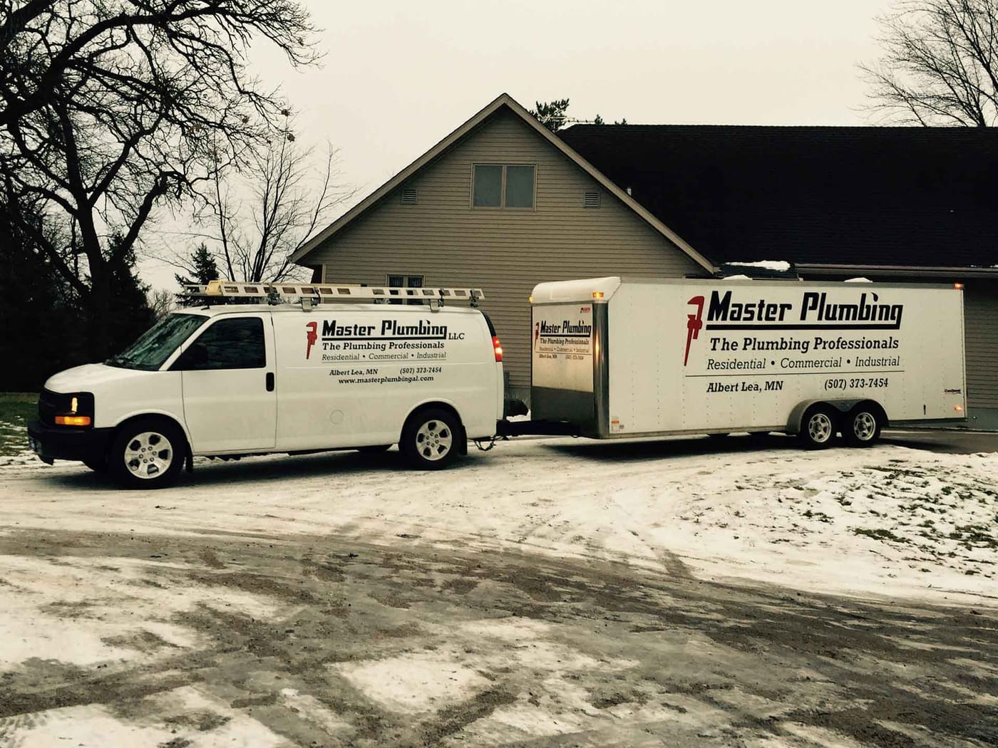 Master Plumbing branded service vehicles parked outside the shop